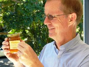 Acting executive director of the Royal Botanic Gardens and Domain Trust, Dr Brett Summerell, applying the first label on the new honey product.